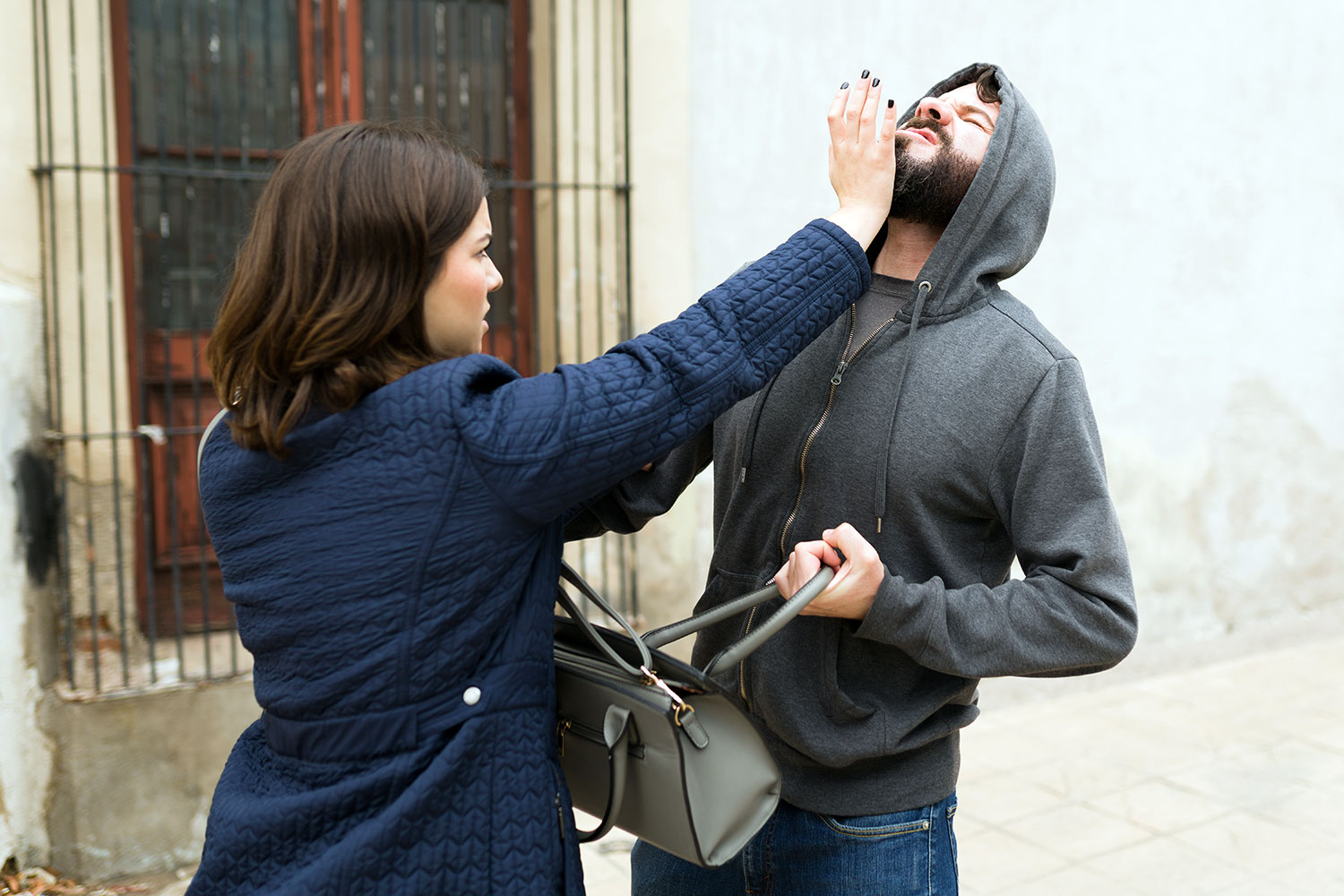 una mujer golpea la barbilla de un ladrón con la palma de su mano