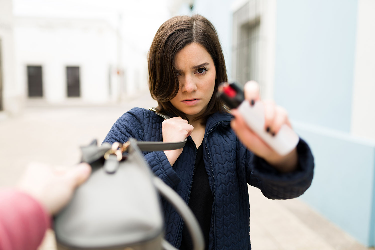Una mujer utiliza un espray de gas pimienta para protegerse de un ladrón