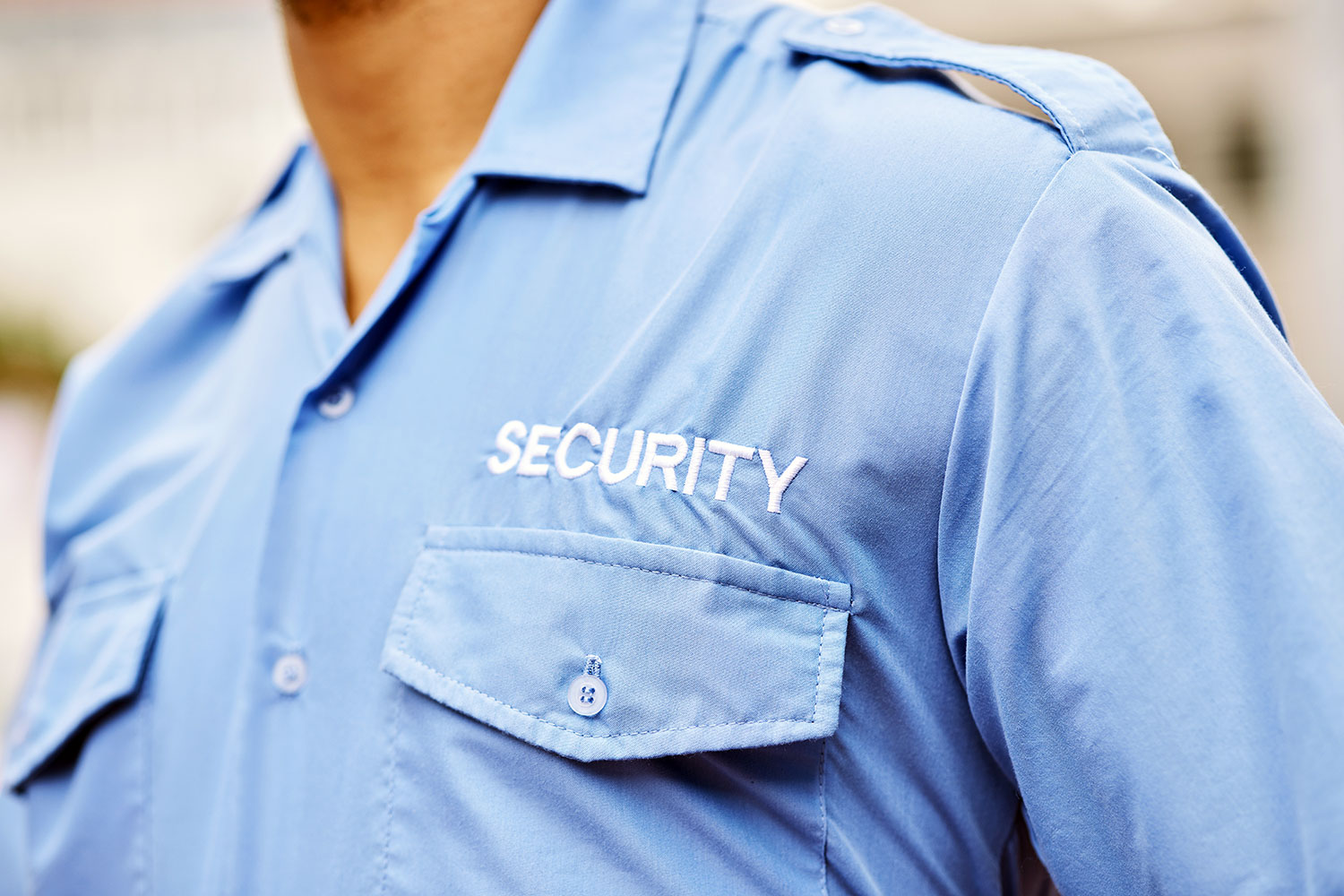 un guardia de seguridad privada con una camisa azul