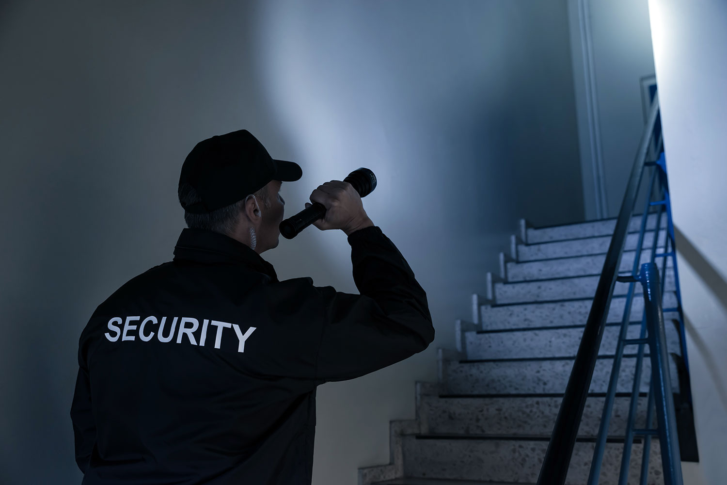 un guardia de seguridad privada utiliza una linterna en labores de comprobación