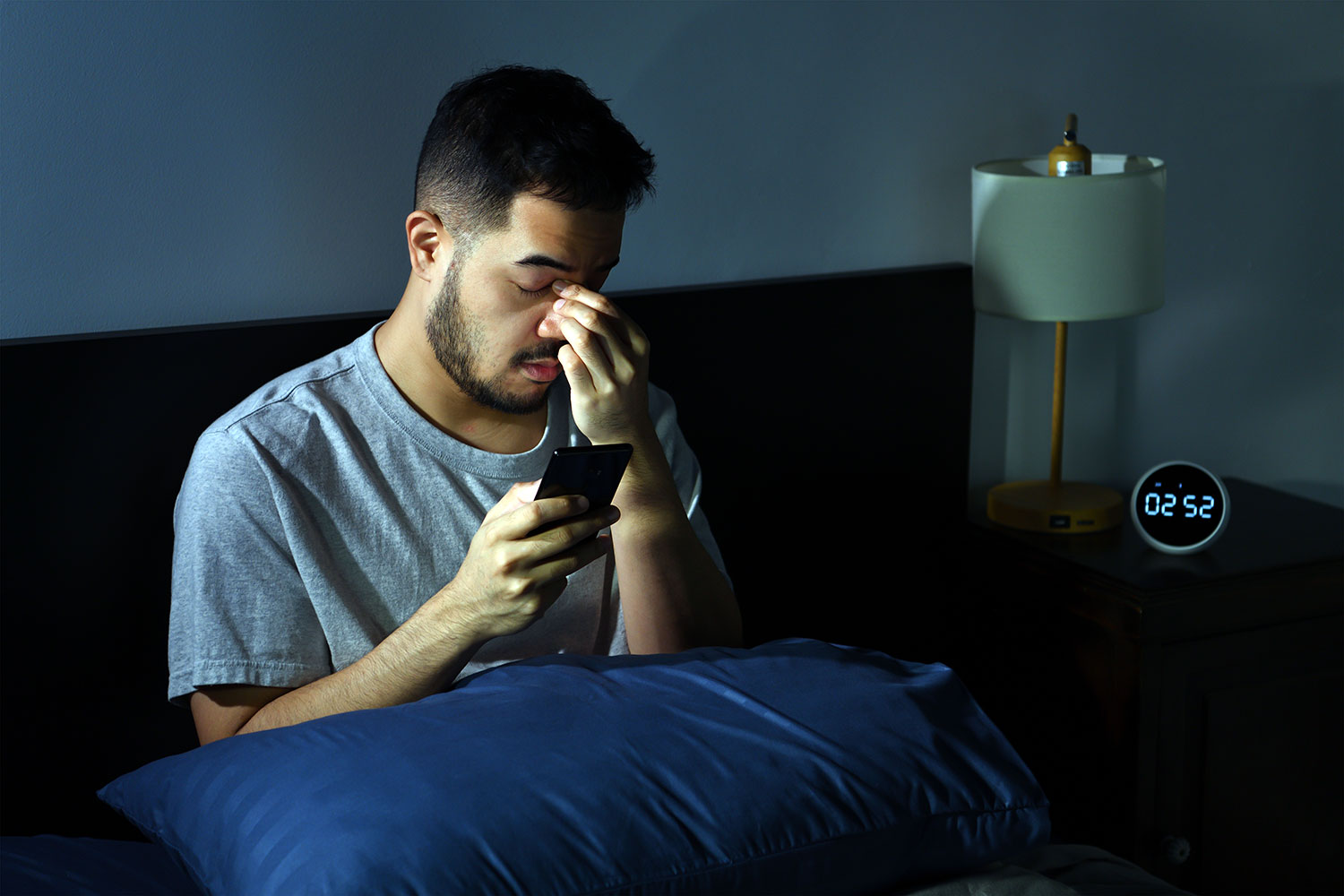 un hombre cansado sostiene un smartphone en la mano