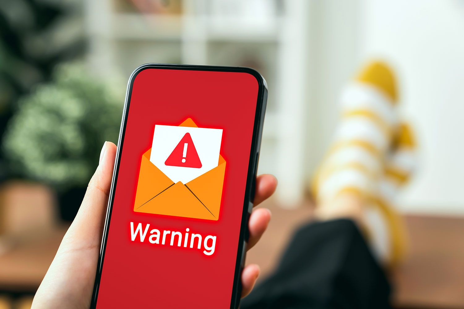 una persona mira una alerta de correo sospechoso en su smartphone