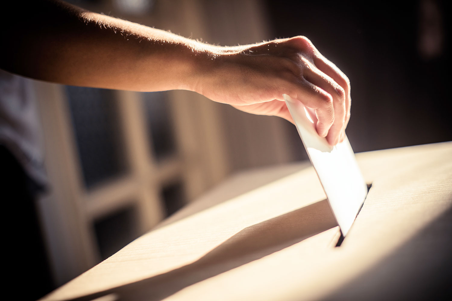 un hombre deposita su voto en una urna