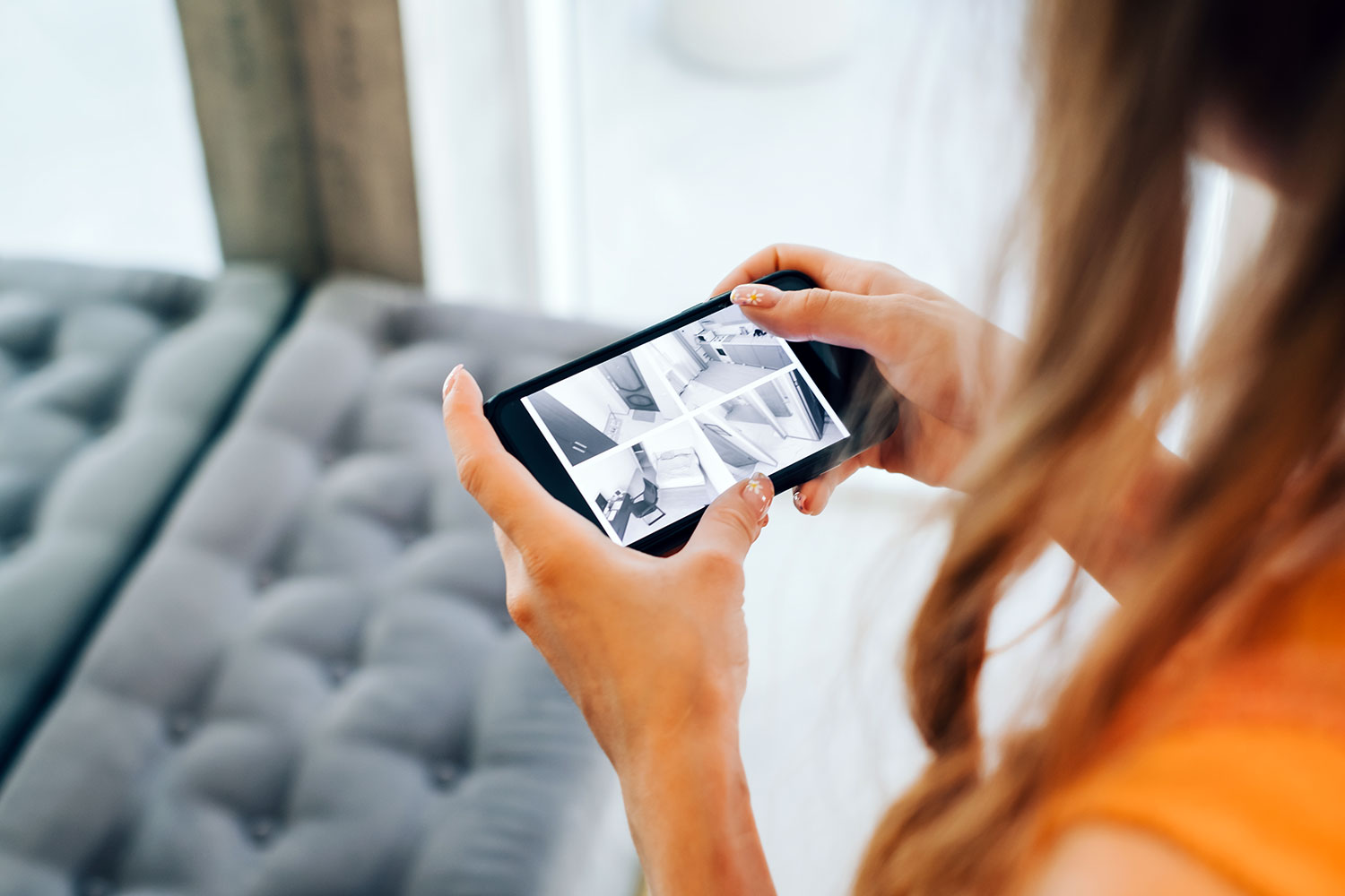 Una mujer visualiza las imágenes del interior de su vivienda a través de un teléfono inteligente