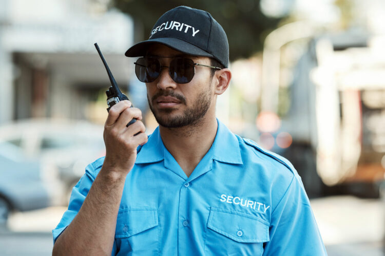 un guardia de seguridad privada habla por su aparato de radiocomunicación