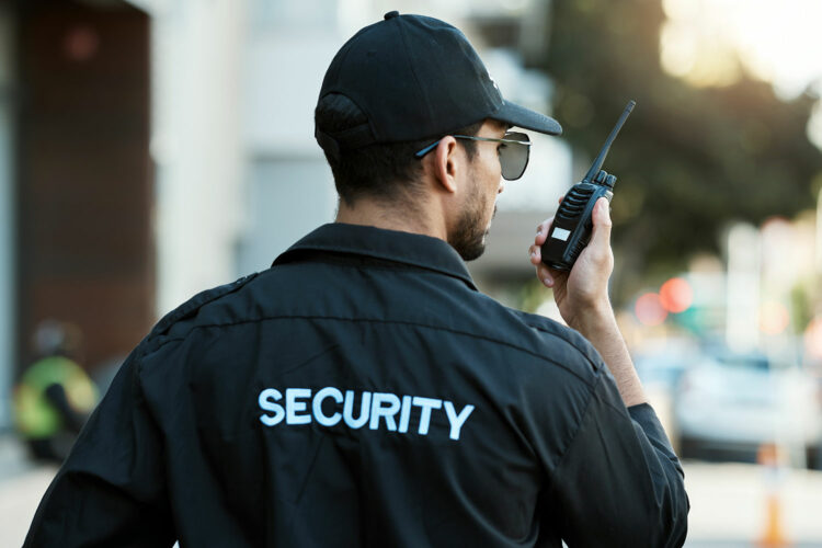 un guardia de seguridad privada habla a través de su walkie talkie