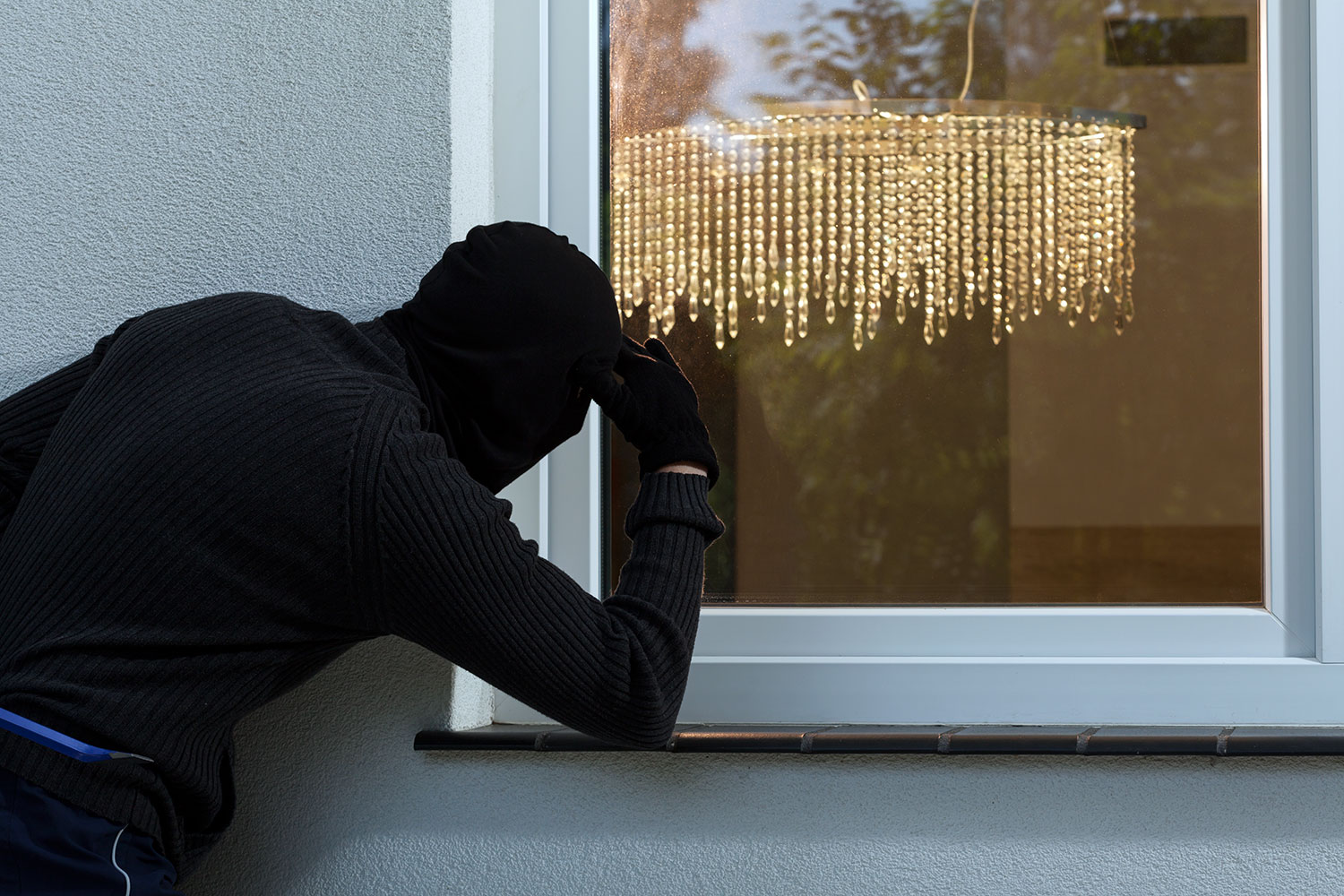 un ladrón mira por la ventana de una vivienda