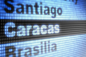 panel informativo de un aeropuerto con el nombre de las ciudades Santiago, Caracas y Brasilia