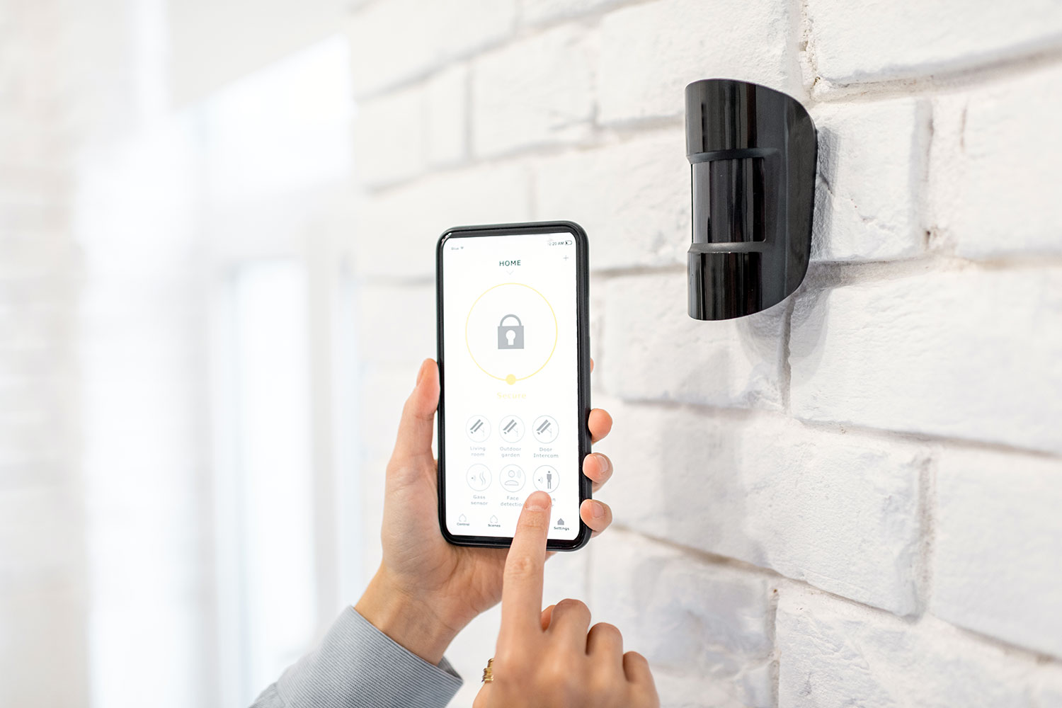 un usuario configura el sensor de movimiento de su hogar con un smartphone