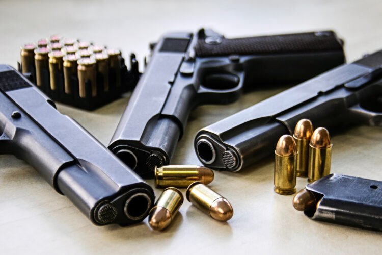 tres pistolas y munición sobre una mesa