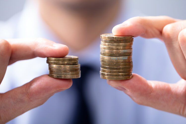 un hombre sujeta monedas con sus dedos