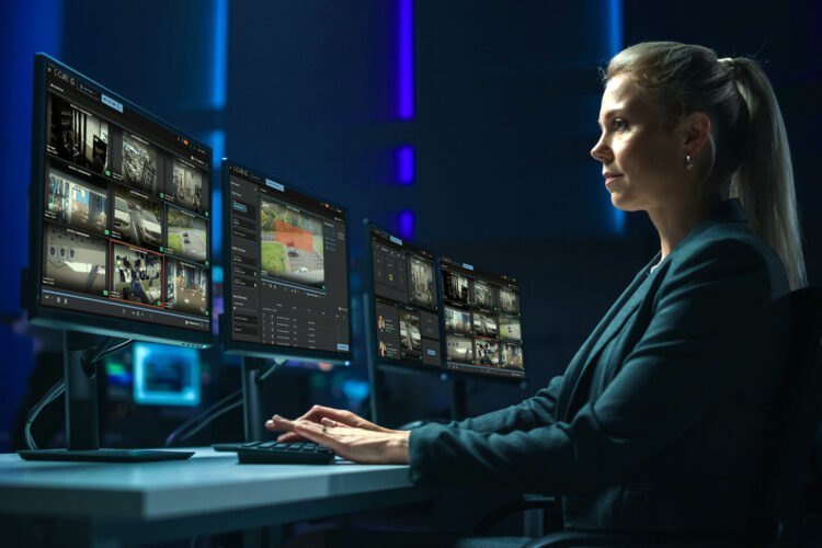 una monitorista observa varios monitores con software de seguridad de Johnson Controls