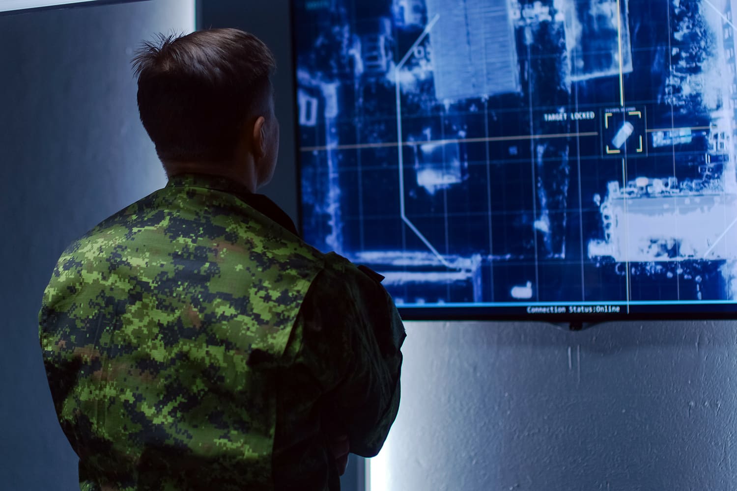 un militar mira una pantalla y hace seguimiento del desplazamiento de un automóvil