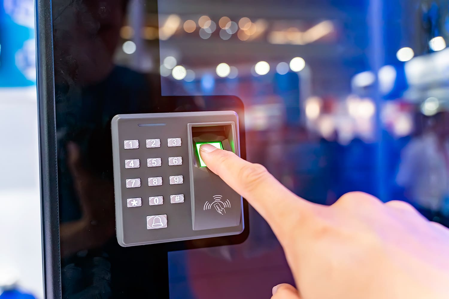 una persona accede a unas instalaciones a través de un lector de huella digital