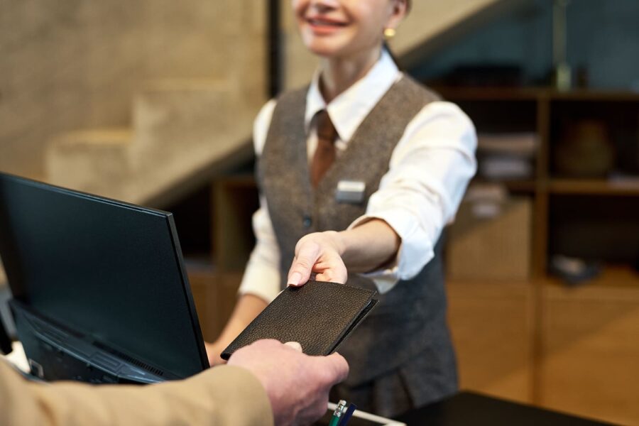 un hombre entrega su pasaporte a la recepcionista de un hotel