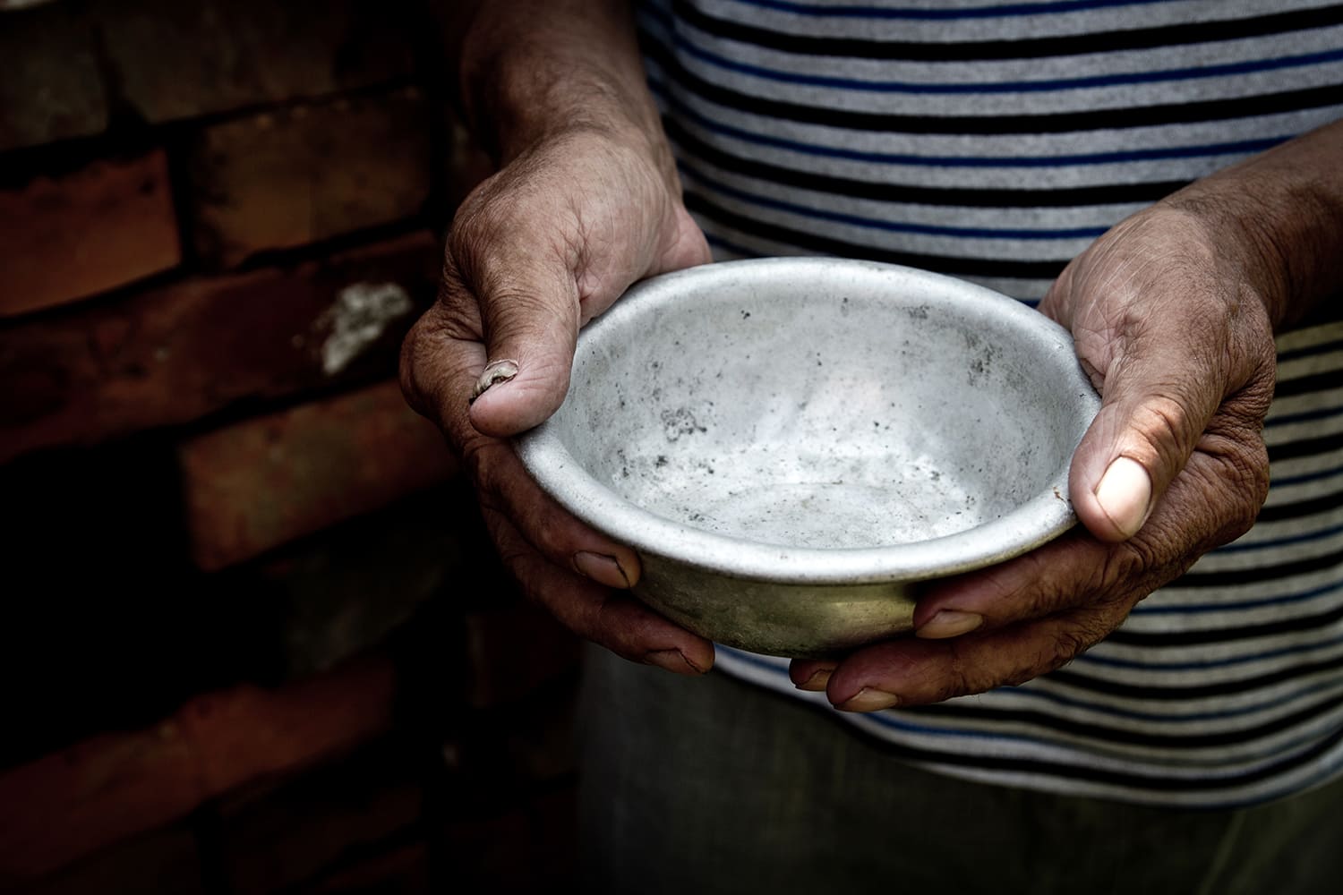 inseguridad alimentaria: un hombre sostiene un cuenco vacío con sus manos