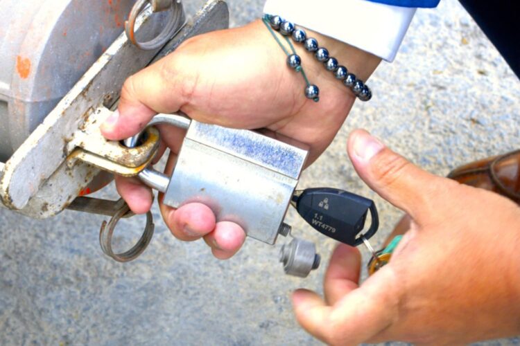 un hombre pone un candado de seguridad de ABLOY en su camión