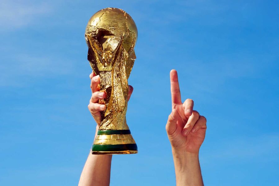 una mano levanta la copa mundial de fútbol