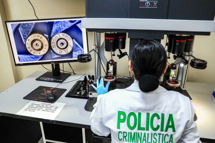 Una funcionaria de la Dirección de Criminalística de la Policía Nacional del Perú realiza una investigación.