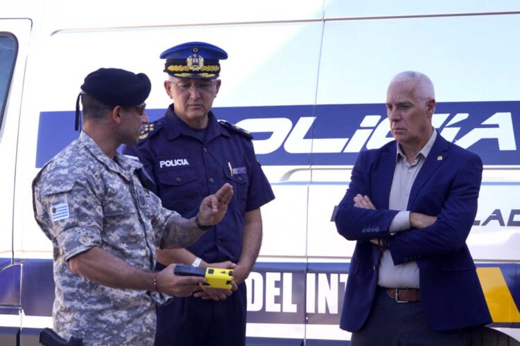 Un policía uruguayo muestra una pistola taser al comisario general José Manuel Azambuya y al ministro del Interior Carlos Negro.