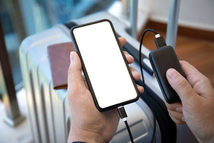 Un pasajero recarga su ‘smartphone’ con un banco de energía en un aeropuerto.
