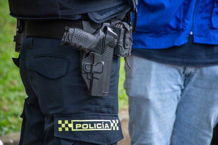 Un agente de la Policía Nacional de Colombia porta su arma reglamentaria durante un operativo de seguridad
